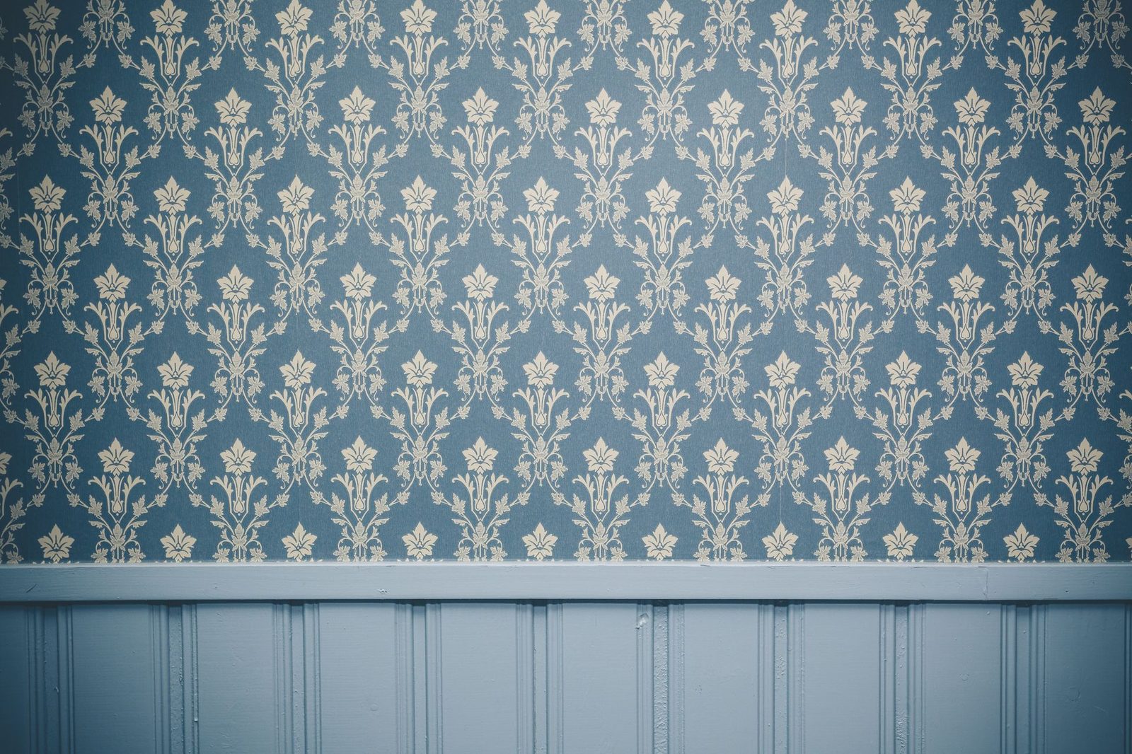 Damask wallpaper installed above painted wainscoting